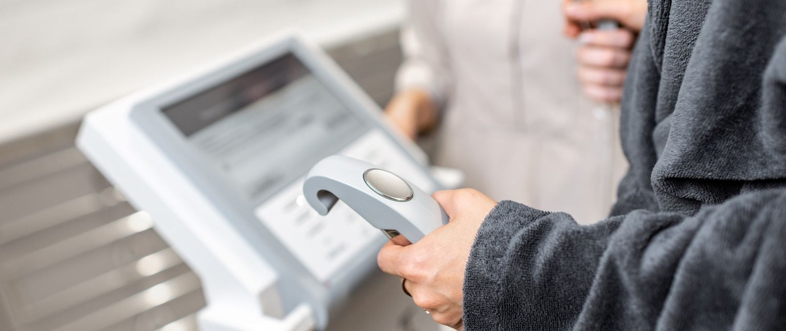 A close-up view of a patient holding the sensors of an InBody scanner.