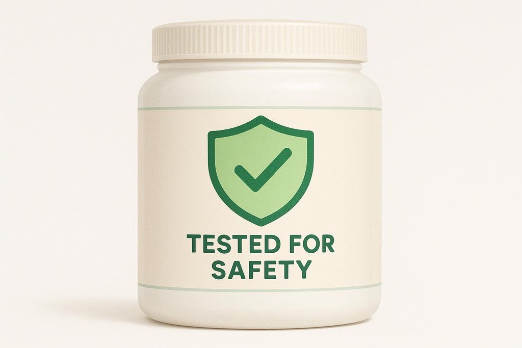 A white supplement tub with a label featuring a green shield icon with a checkmark inside, and the text 'TESTED FOR SAFETY' below it, indicating third-party testing.