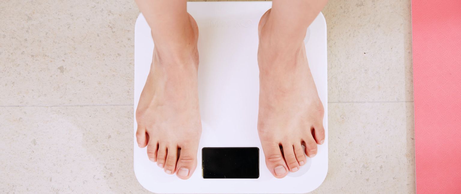 Overhead view of a person standing on a white digital scale.