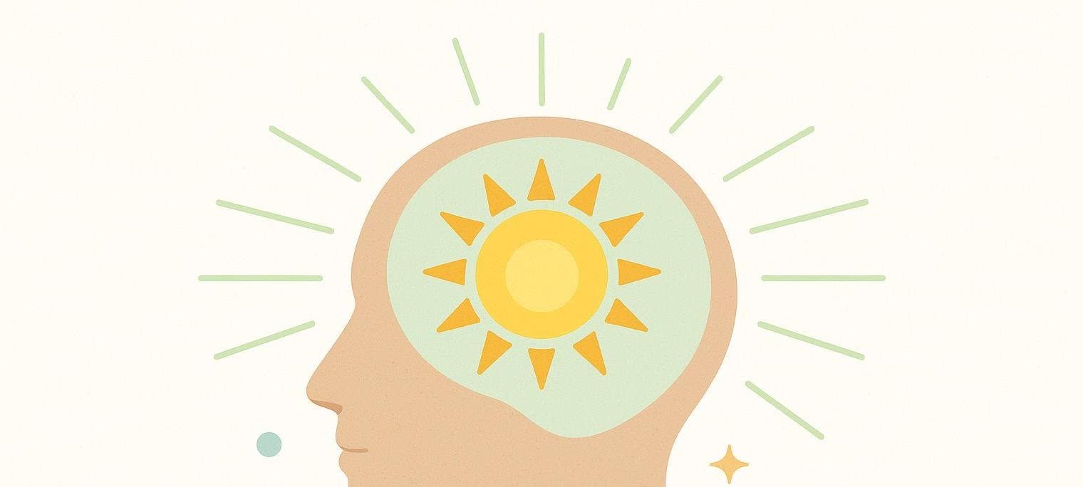 An illustration of a human head in profile with a bright yellow sun inside, radiating light green rays outward, symbolizing energy, focus, and positive thinking.