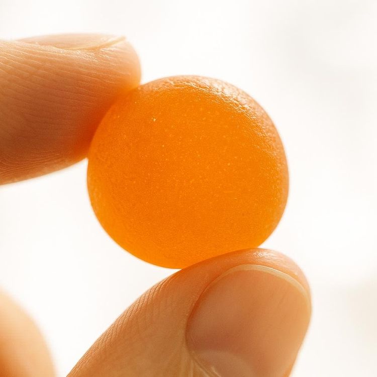 Close-up of a single orange gummy vitamin.
