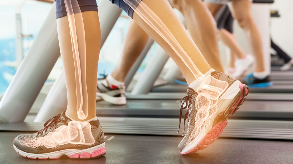 Detailed view of bones in legs and feet while a person walks on a treadmill, emphasizing bone structure and movement.