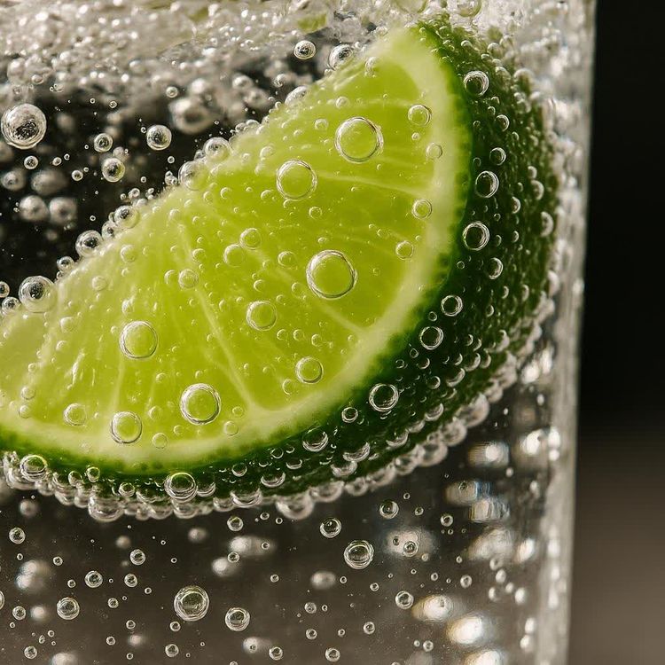 Close-up of sparkling soda water with a lime wedge.