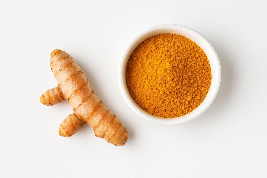 A fresh turmeric root lies beside a bowl of golden curcumin powder, highlighting the natural source of the potent anti-inflammatory supplement.