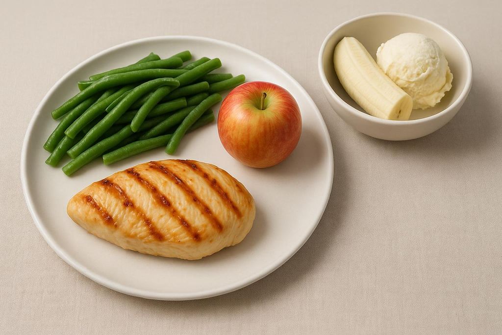 A full-day meal for the Military Diet, consisting of a grilled chicken breast, green beans, and an apple on a white plate, with a separate bowl containing a banana and a scoop of vanilla ice cream.