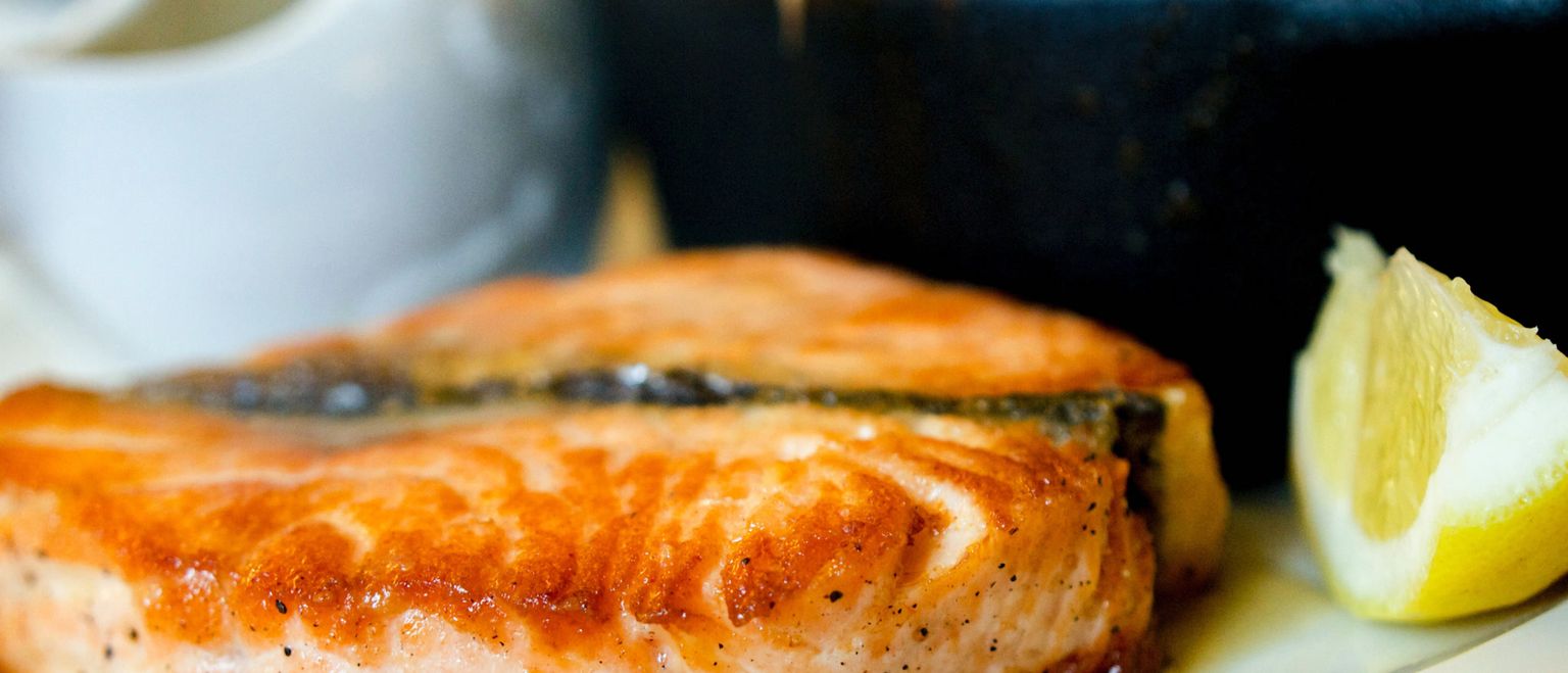 Close-up of grilled salmon fillet with a wedge of lemon.