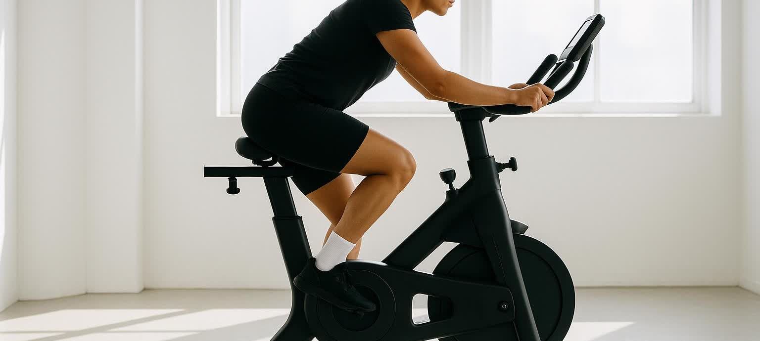 Person on a stationary bike in a bright gym interior